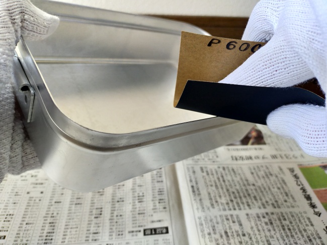 荒めの紙やすりでメスティンのバリ取りをする様子